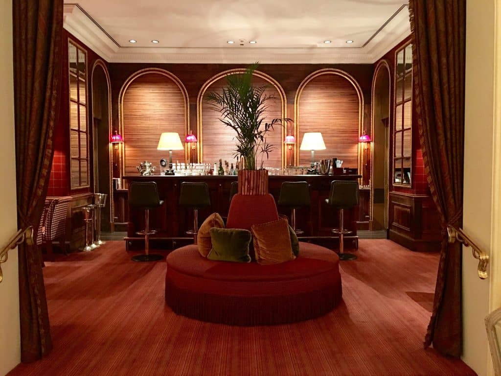 The Oleander Bar at Brenners Park-Hotel & Spa with red round couch and with dark wood bar