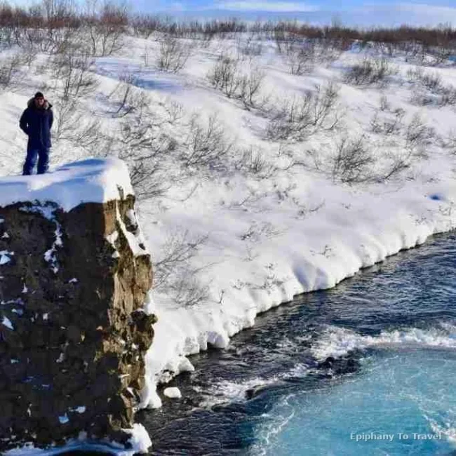 Kevin on stone pillar looking over falls