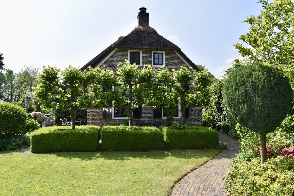 Very neat garden at a home with trees in front of home in Giethoorn Netherlands