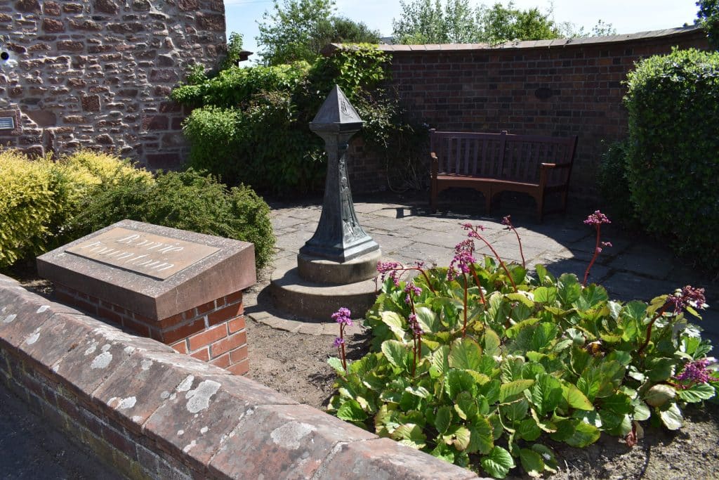 Monument to J.M. Barrie in the town of Kirriermuir Scotland with bench and garden